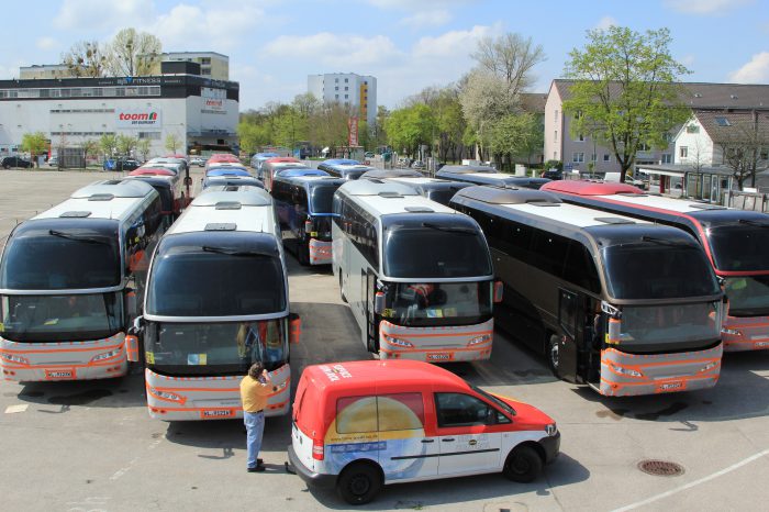 Several buses are in a parking lot